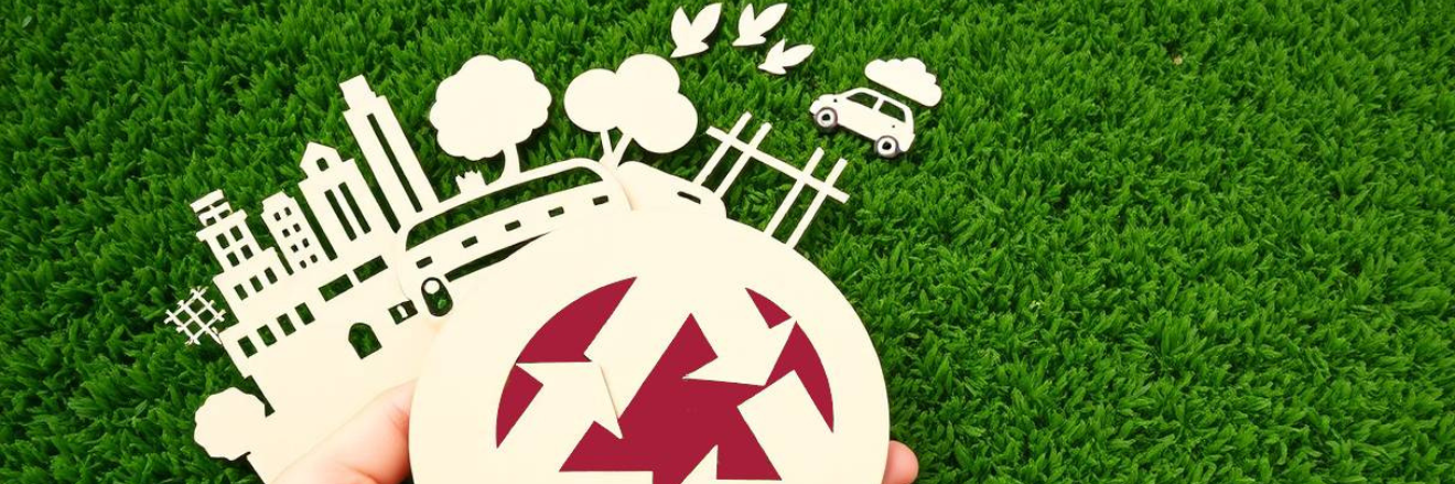 immagine con profili di grattacieli, alberi e macchine, con un prato verde sullo sfondo